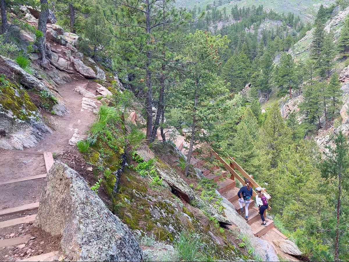 Hikers descending the stone staircase section of the Walker Ranch Loop above South Boulder Creek
